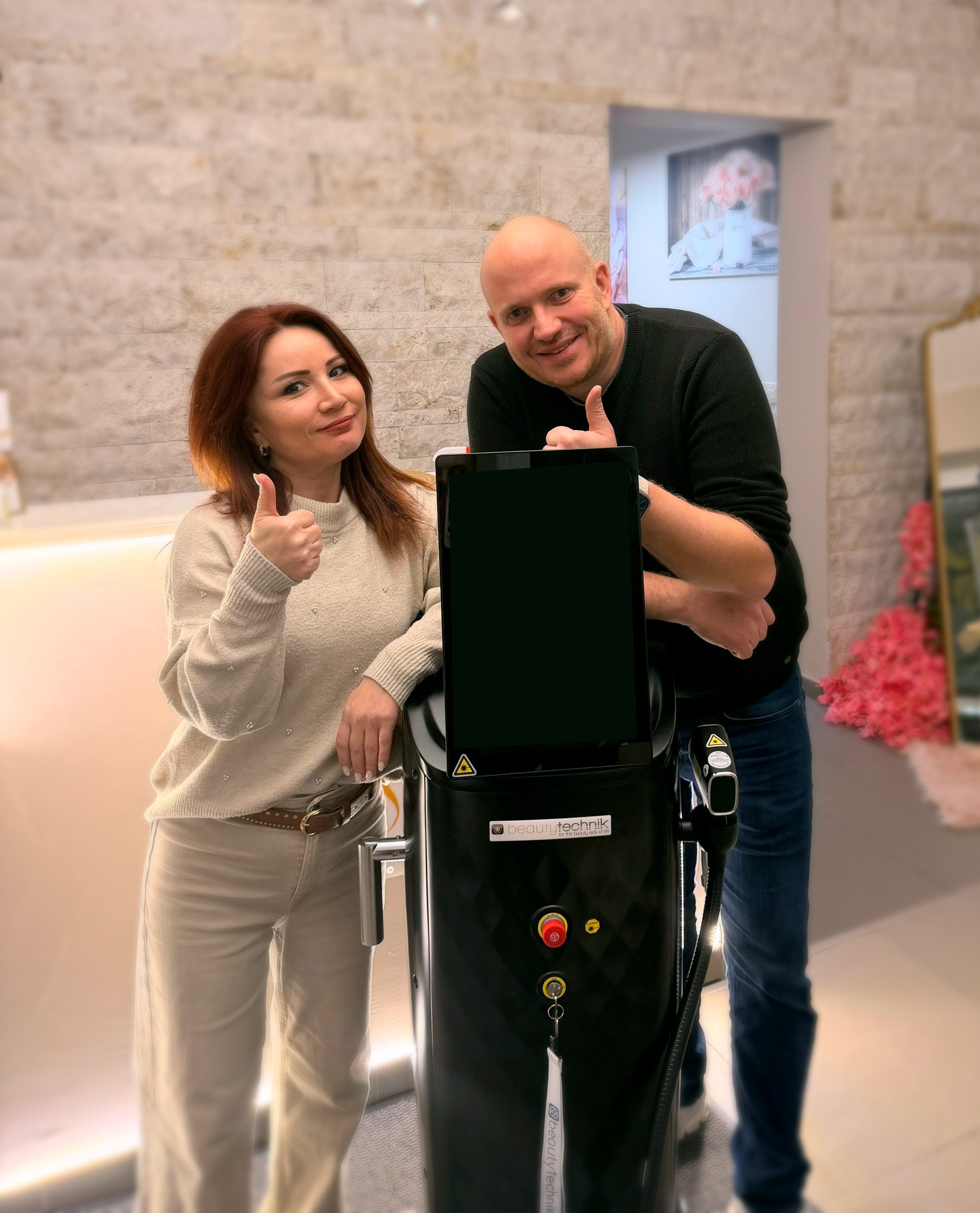 Zufriedene Kundin und Kunde mit beautytechnik Gerät im Studio